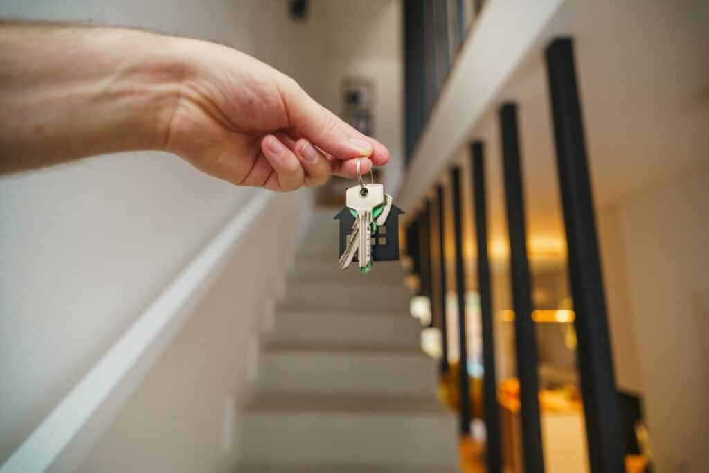 hand holding house keys in modern interior