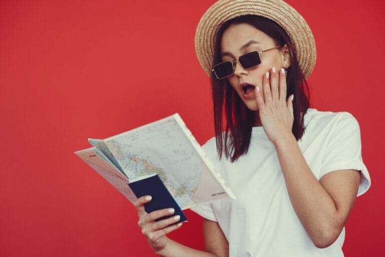 young woman with passport and map on red background