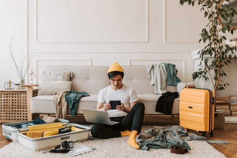 a man using his laptop in a messy living room